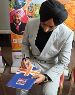 Satinder Sartaaj the famous Sufi songs signing a copy of the British Sikh Report.jpg