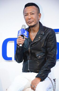 Toshihiro Nagoshi, speaking into a microphone
