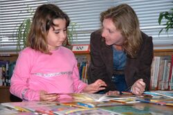 US Navy 061026-N-5271J-014 Jennifer Tonder (right), a teacher's aide for a 3rd-4th grade multi-age class, discusses the various books available from the Reading Is Fundamental (RIF) grant given to Sasebo Elementary School with.jpg
