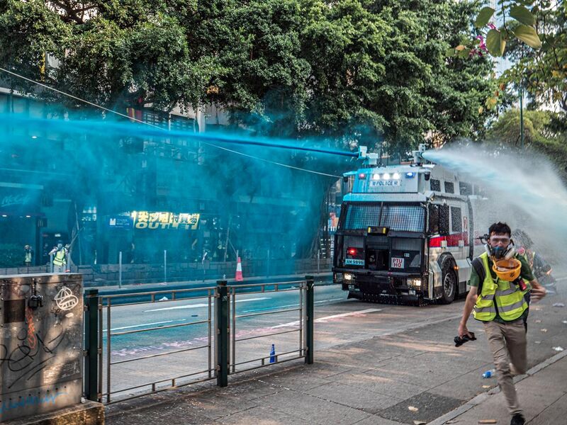 File:Water cannon in Hong Kong delivering water with blue pigment.jpg