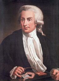 Painting of a middle-aged man sitting by the table, wearing a wig, black jacket, white shirt and white scarf.