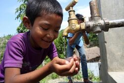Boy drinks from a tap at a NEWAH WASH water project in Puware Shikhar, Udayapur District, Nepal. (10677936093).jpg