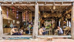 Craftmen at work, bamboo basket weaving and textile mobile sculptures, in Heuan Chan heritage house, Luang Prabang, Laos.jpg