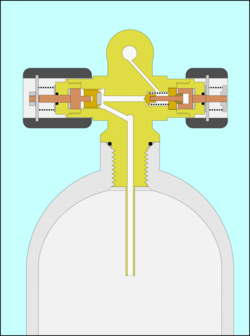 Cut-away section through a scuba cylinder valve mounted in a cylinder, showing the air passages and working parts, including the open main valve and the spring-loaded reserve mechanism in the closed position.