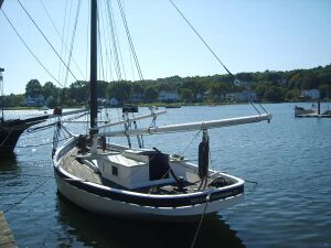 Nellie at a pier viewed from her port stern quarter.