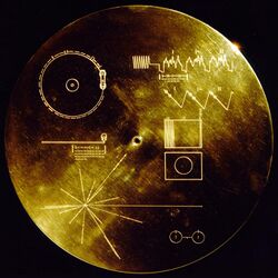 Photograph of a gold phonographic record with images of soundwaves on it