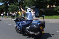 Gendarmerie motor officer raising arm in traffic.jpg