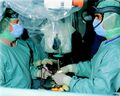 A surgical team in Germany. It has been suggested that surgeons and nurses adopted a cyan-colored gown and operating rooms because it is complementary to the color of red blood and thus reduced glare, though the evidence for this claim is limited.