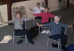 photo of a movement-restricted class doing yoga in chairs