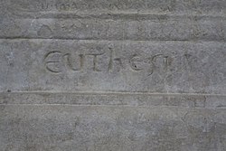 Detail of an engraved stone with a difficult-to-interpret inscription