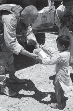Captain Kevin Kit Parker hands out hygiene pack in Kandahar.jpg