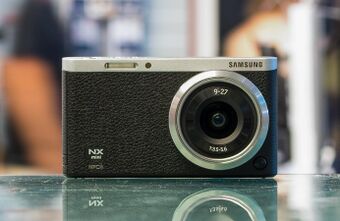 Black colored Samsung NX mini camera with lens
