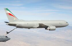 A mostly-gray KC-767, with refueling probe extended, transferring fuel to a B-52 in the left-bottom hand corner