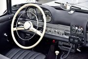 Black-and-white photo of a roadster interior, with additional equipment