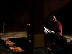 Tibetan Buddhist Monk in natural light reading sacred texts in 2006.jpg