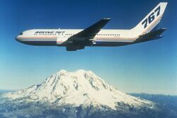 Boeing twin-engine jetliner in flight near a snow-capped mountain