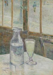 A table in a cafe with a bottle half filled with a clear liquid and a filled drinking glass of clear liquid