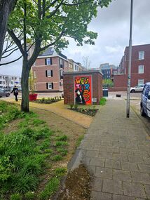 a garden path with yellow gravel that runs diagonally to a sidewalk flanked by new shrubbery