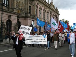 Street demonstration with banners, passing an official building