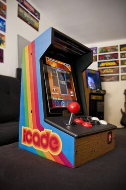 An Apple iPad rests within a portable wooden arcade cabinet decorated in a bright, retro style.