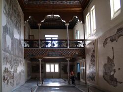 Salle d’Althiburos, ancienne salle de musique du palais avec une tribune et des mosaïques sur les murs et le sol.