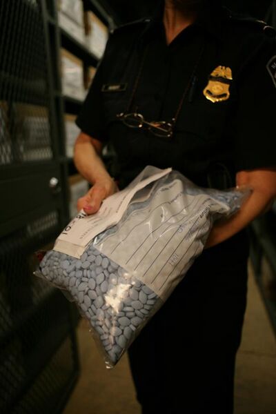 File:CBP with bag of seized counterfeit Viagra.jpg