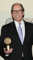 A waist-up shot of Harry Friedman holding an award