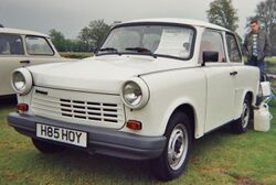 Two-door sedan with a man standing behind it