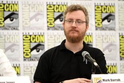 Photograph of Mark Darrah, the game's executive producer, sitting at a microphone looking to his right