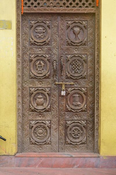 File:Carved door with 8 auspicious signs, Nepal.jpg