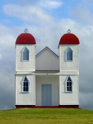 Simple white building with two red domed towers