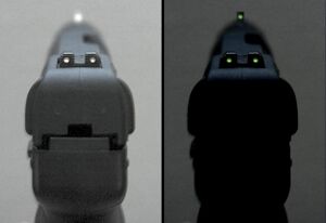 Photo of the tritium-illuminated fixed sights of the Five-seven USG pistol, in normal and dim lighting.