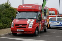 Red van decorated with pictures of different types of ice lolly which says "Mr Whippy" on the front of the roof