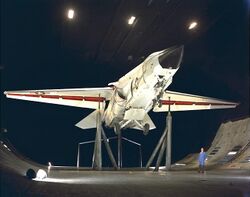 A F-111B on support inside a large wind tunnel