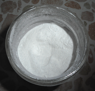 Neotame, a fine white powder, in a jar