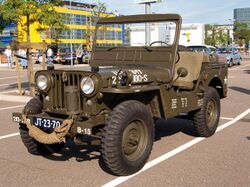 Military jeep, showing the prominent bar grip tread pattern of its nearest front tyre