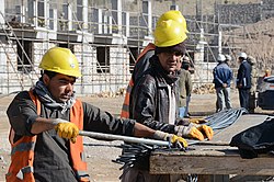Workers bend reinforcing bar, or rebar, to strengthen concrete for a facility that will house 372 students as part of the Herat University Women's Dormitory Project in Herat province, Afghanistan, March 11 140311-A-DT641-067.jpg
