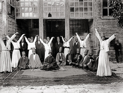 Whirling dervishes in Galata Mawlawi House, 1870.png