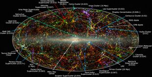 A map of the universe, with specks and strands of light of different colors.
