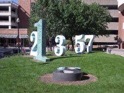 Several tall Arabic numerals standing upright in a lawn