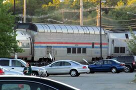 A stainless steel passenger dome rail car with red, white, and blue stripes of equal width on the side