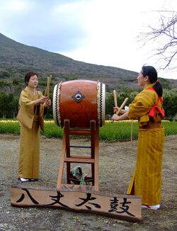 Two women wearing kimonos perform traditional Hachijō-daiko.