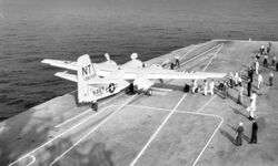 Black and white photograph of an aircraft on the deck of an aircraft carrier