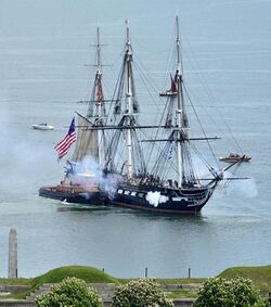 USS Constitution fires its cannons as it is tugged through Boston Harbor. (51200023793) (cropped).jpg