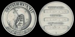 Apollo 12 mission emblem and crew names (front). Dates (launch, lunar landing, and return), and serial number 1 (back)