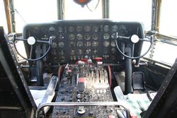 This is the cockpit of a Boeing 377. It does not include the stations of the navigator and flight engineer. You have yokes, rudder pedals, thrust levers, and a lot of "steam gauges", as is typical for this era of aircraft.