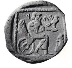 A coin showing a bearded figure seating on a winged wheel, holding a bird on his outstretched hand