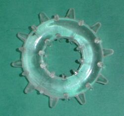 A clear, soft plastic ring with knobs