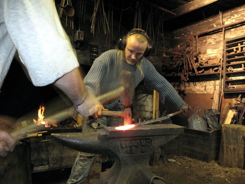 File:3 tourist helping artist blacksmith in finland.JPG
