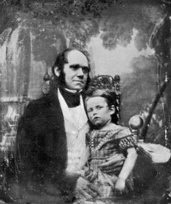 Darwin in his thirties, with his son dressed in a frock sitting on his knee